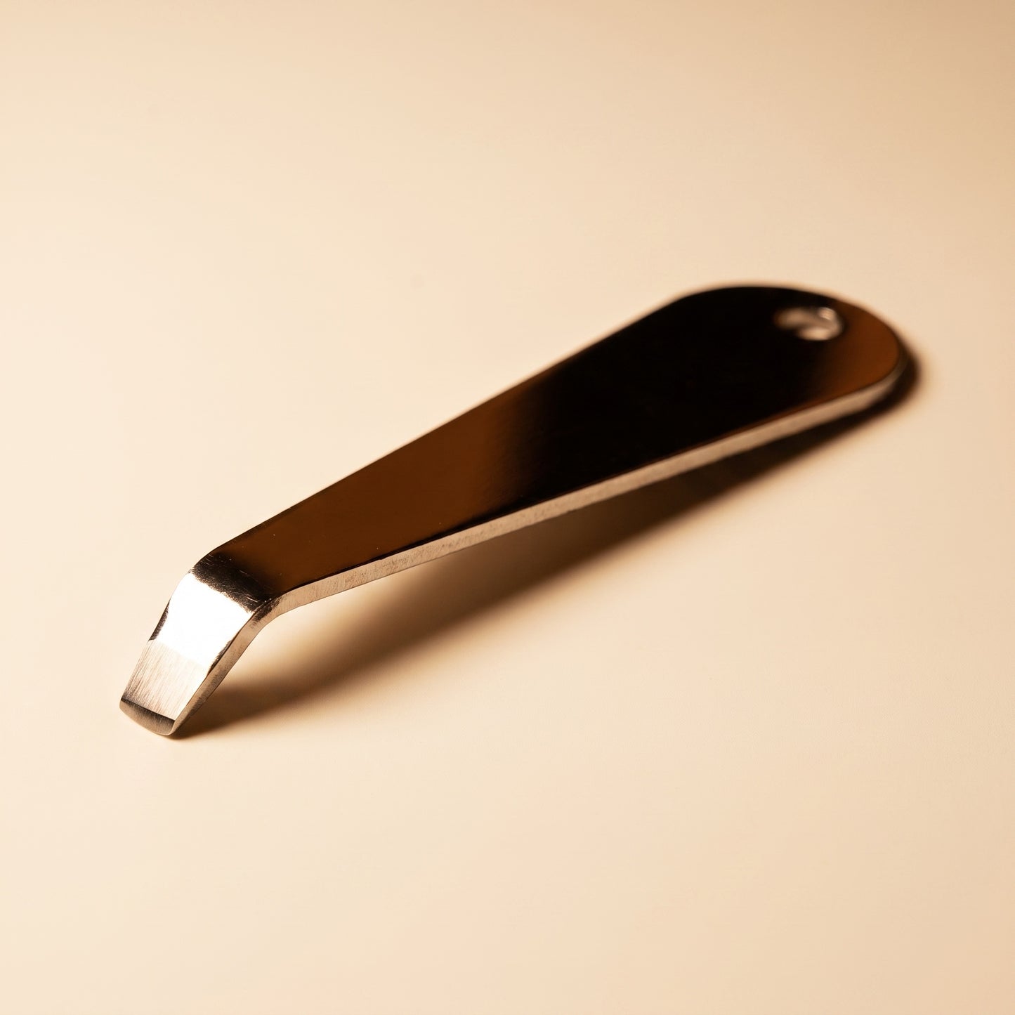 Close-up of the bent hook tip on the stainless steel portafilter basket removal tool
