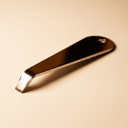 Close-up of the bent hook tip on the stainless steel portafilter basket removal tool
