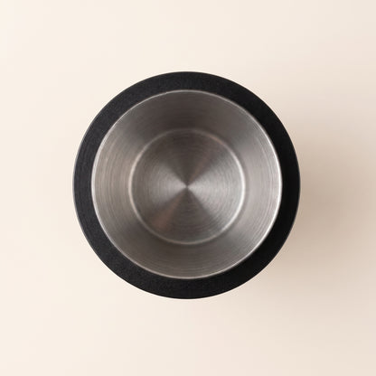 Black dosing cup top-down view showing the smooth interior and narrow base