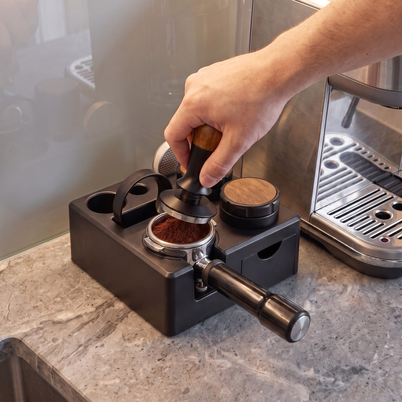 Tamping station with a portafilter locked into the cradle, ready to distribute and tamp