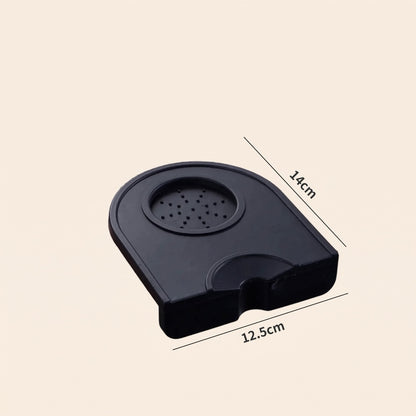 Silicone corner tamping mat on a home espresso bench beside a portafilter