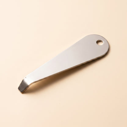 Portafilter basket removal tool profile view showing flat blade and hanging hole, polished steel