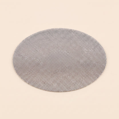 Reusable stainless mesh puck screen on flat cream background, front view, 150 micron