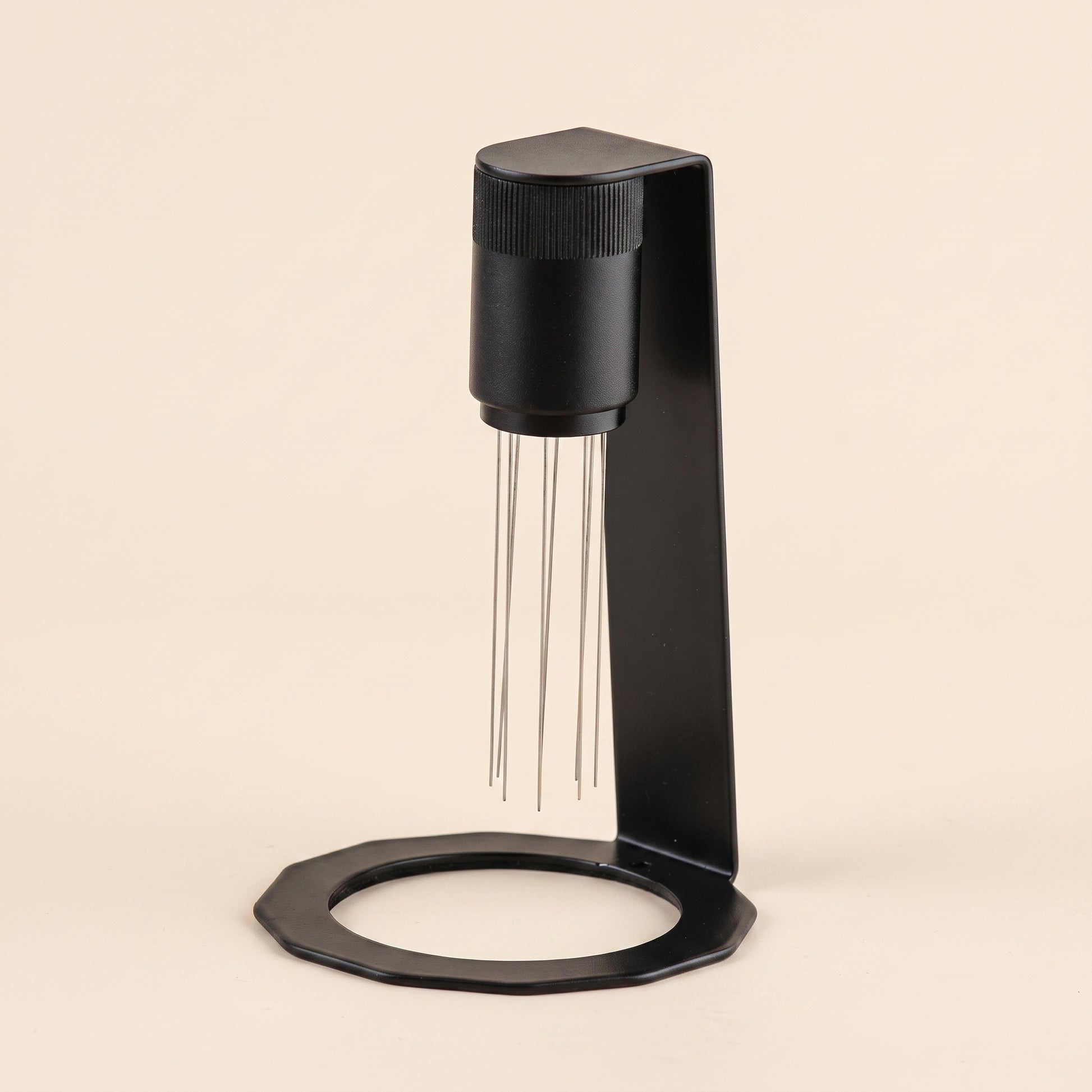 WDT tool in matte black on a flat cream background, front view, 8 stainless steel needles