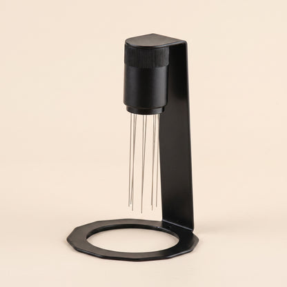 WDT tool in matte black on a flat cream background, front view, 8 stainless steel needles