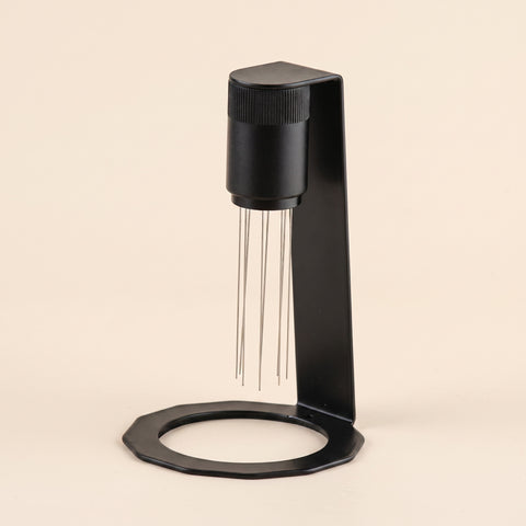 WDT tool in matte black on a flat cream background, front view, 8 stainless steel needles